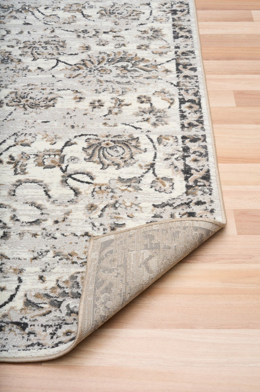 Close-up of grey and cream area rug border with textured low-pile weave