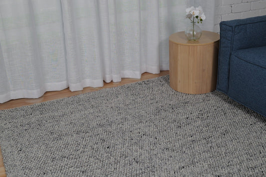 Grey speckled area rug with low-pile, textured surface