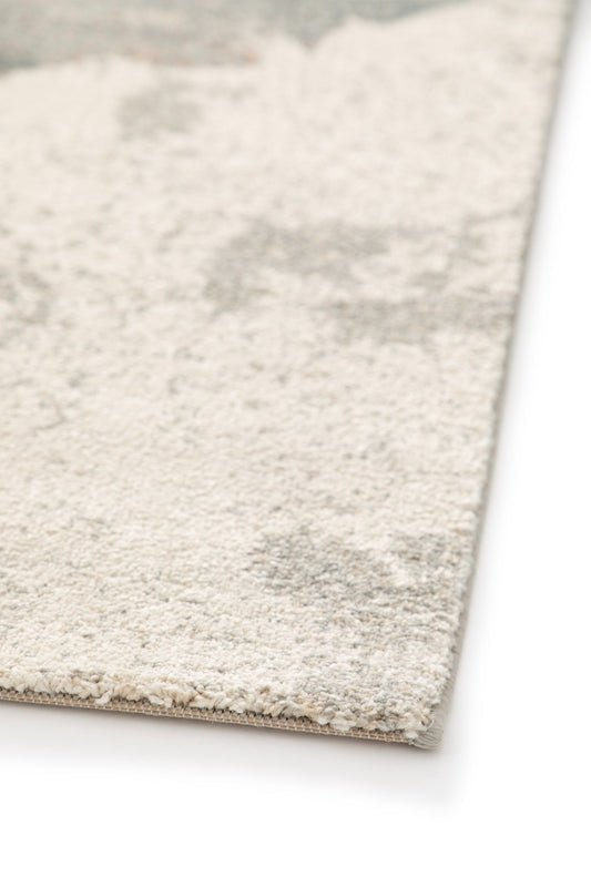 Flat edge of floral area rug with beige border on a light background
