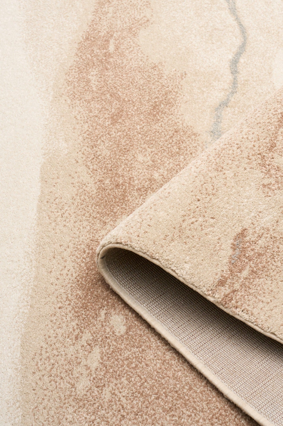 Beige and tan rug corner with visible textured underside and bound edge
