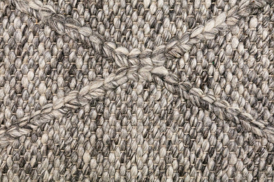 Dark grey wool rug close-up of looped woven fibers