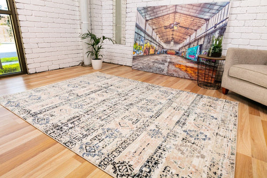 Ivory beige area rug with abstract geometric pattern and dark blue accents