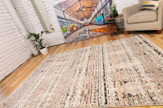 Contemporary area rug with distressed cream beige base and black pattern, medium pile