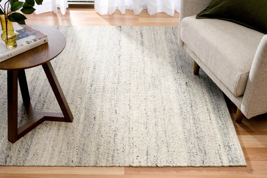 Grey wool area rug full view with textured speckled surface and horizontal bands