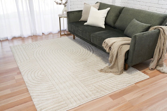 Ivory large area rug with textured spiral and wave motif on hardwood floor