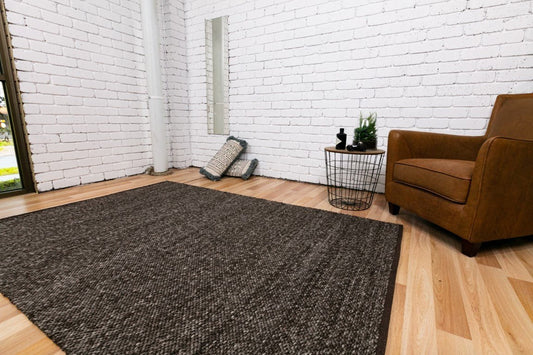 Dark gray-brown wool area rug on hardwood floor