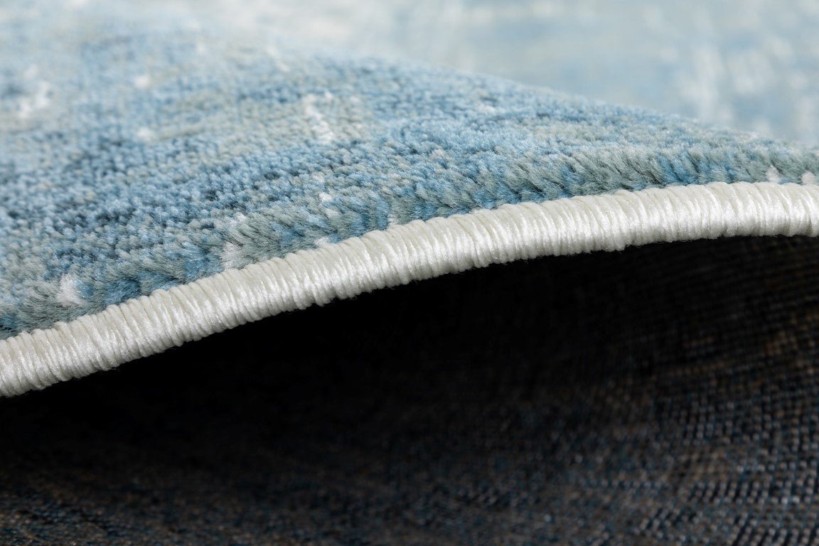 Rug corner close-up showing white binding and blue pile | Raffia 7444 Sky Modern Polypropylene Area Rug - Rugs Point Australia