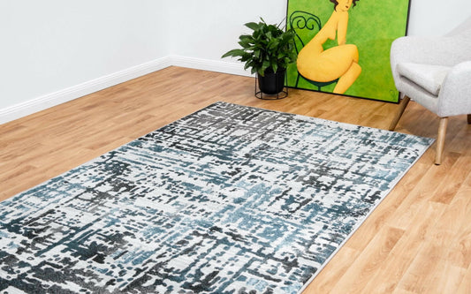 Grey-blue abstract area rug with distressed geometric pattern