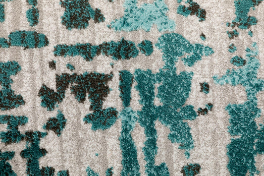 Textured abstract motif rug in teal and dark teal on a light gray base