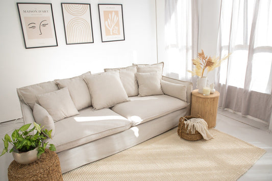 Beige wool rug laid flat with textured surface beneath a modern light-colored sofa