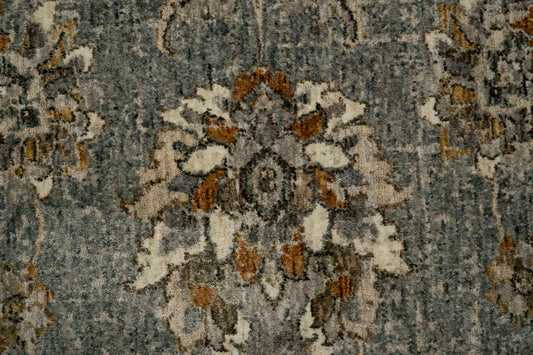 Close-up of blue-gray rug with distressed floral medallion design in tan
