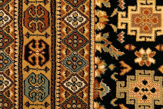 Close-up of black and gold traditional rug with floral medallion motifs