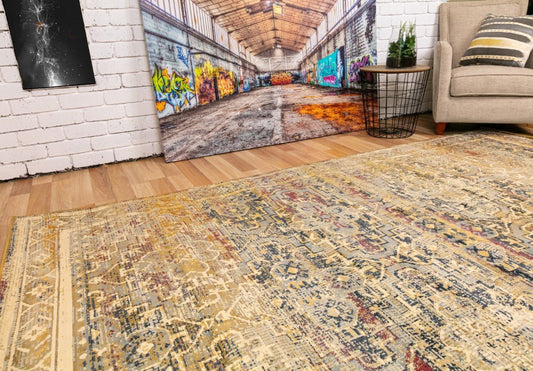 Traditional area rug with distressed beige, blue, and gold geometric design