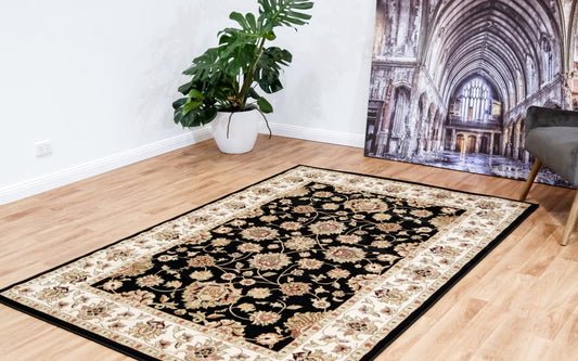 Traditional black rug with cream floral medallion border and ornate golden patterns