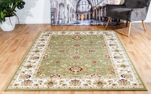 Green traditional area rug with ornate floral medallion and cream border