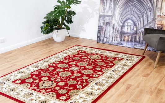 Red traditional area rug with ornate floral pattern and cream border