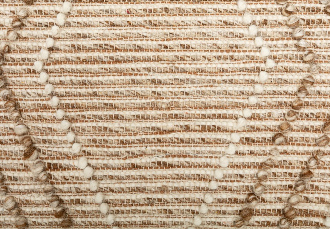 Beige wool area rug texture close-up with woven lines and tufted details