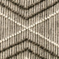 Woven wool rug detail with raised lattice texture and cream pom fringe accents.