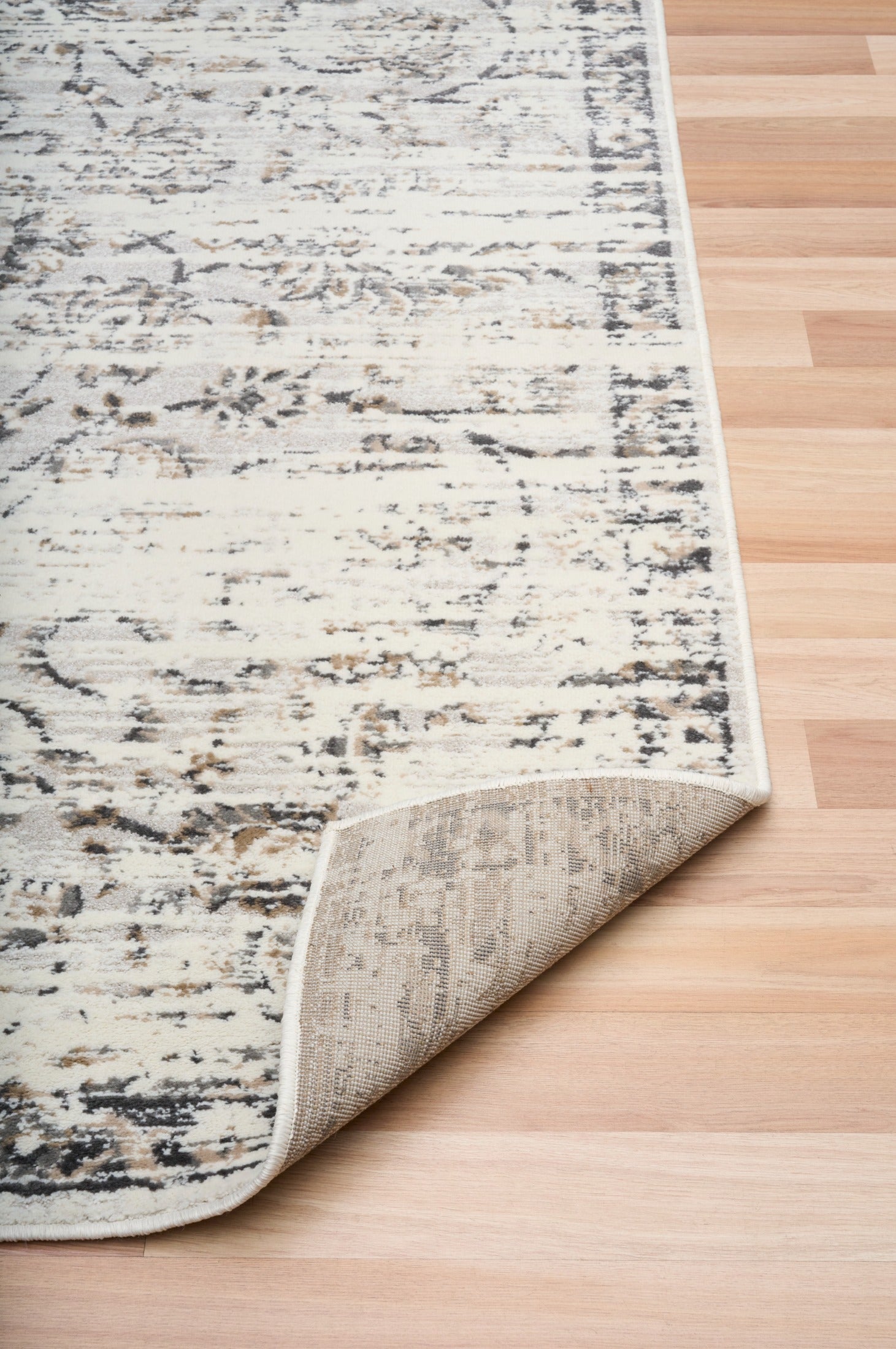 Close-up of light gray distressed abstract area rug pattern and bound edge