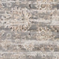 Close-up of light gray rug with cream abstract distressing and textured weave
