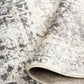 Gray and white rug pile with abstract distressed pattern and stitched edge