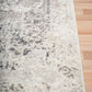 Gray and white abstract area rug with distressed pattern and flat bound corner