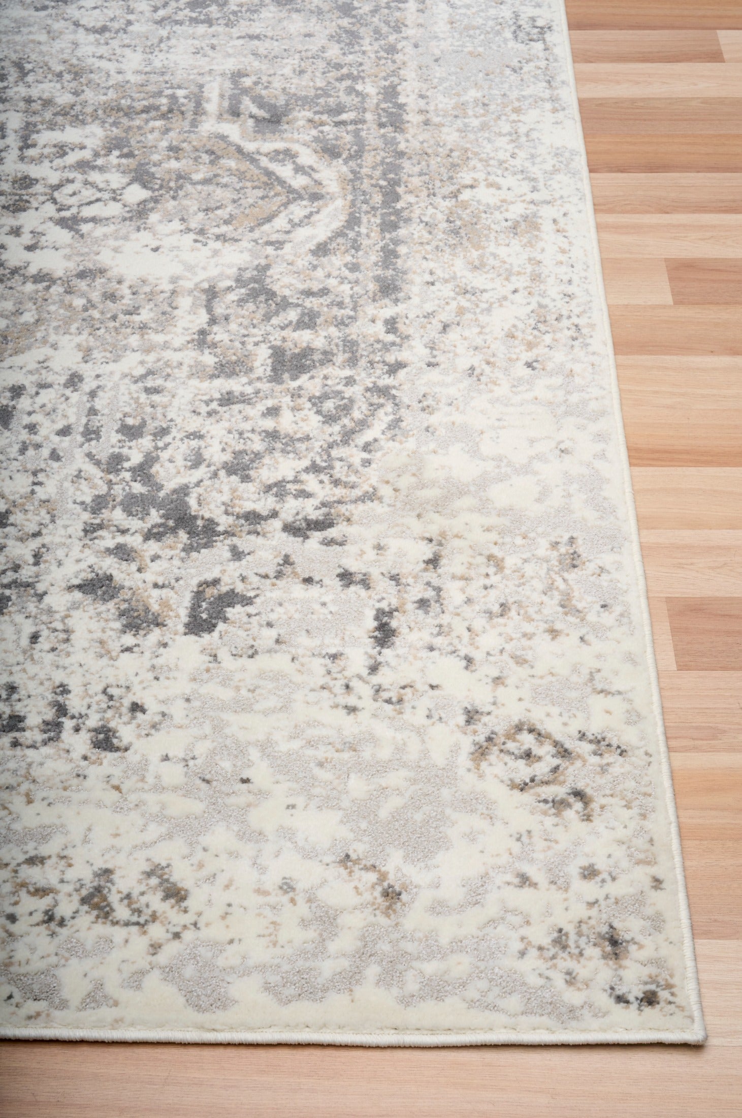 Gray and white abstract area rug with distressed pattern and flat bound corner