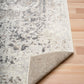 Gray and white abstract area rug with distressed pattern and visible bound edge
