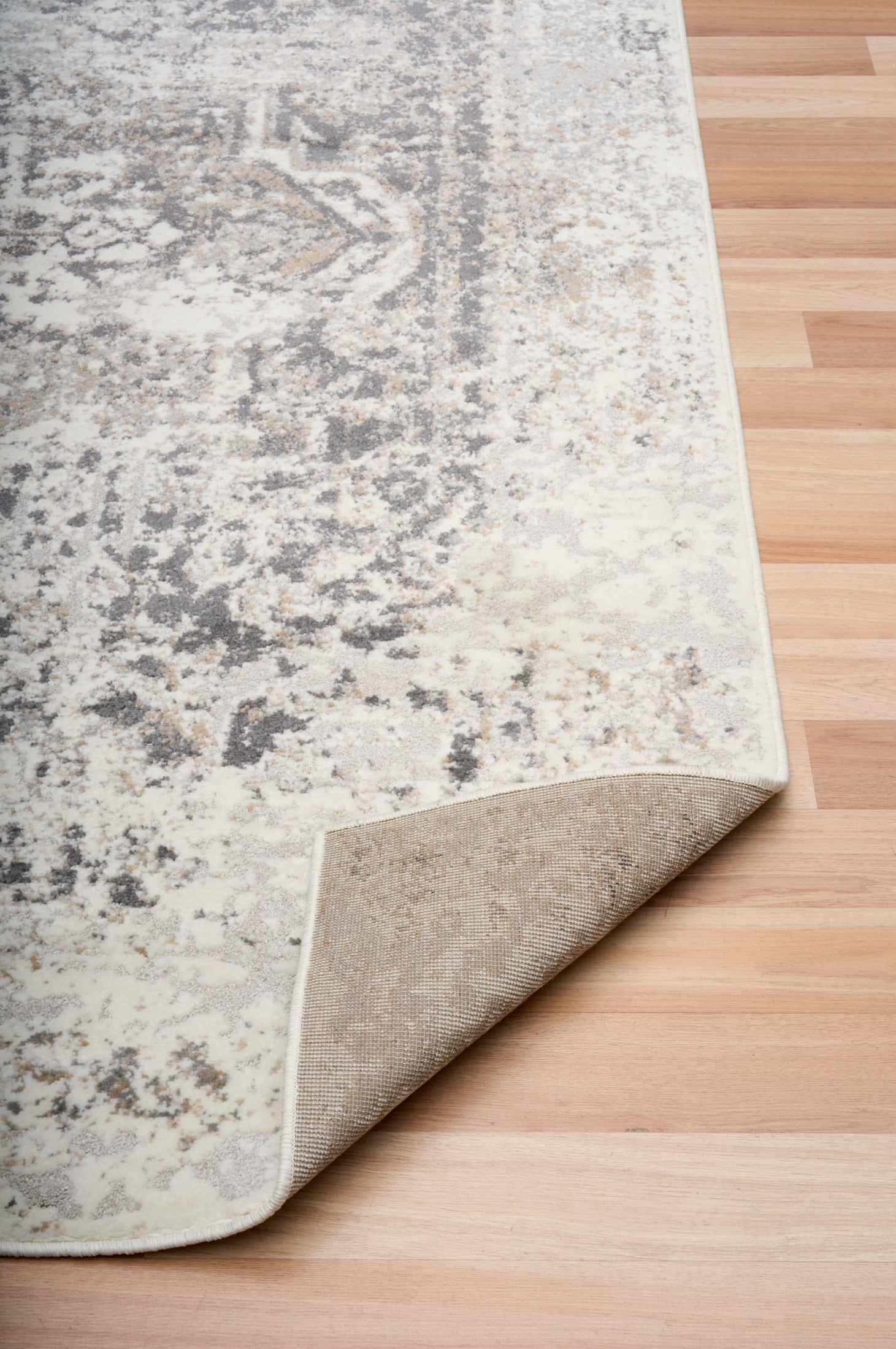 Gray and white abstract area rug with distressed pattern and visible bound edge