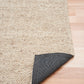 Beige woven rug corner with dark backing underside