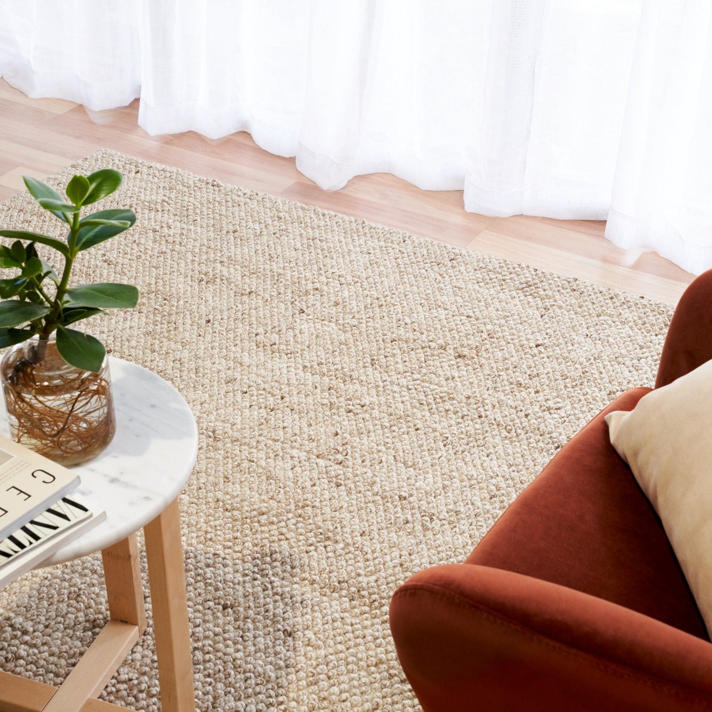 Beige woven area rug on hardwood floor, textured surface