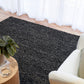Charcoal textured area rug with tight looped weave, on a hardwood floor