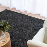 Charcoal textured area rug with tight looped weave, on a hardwood floor
