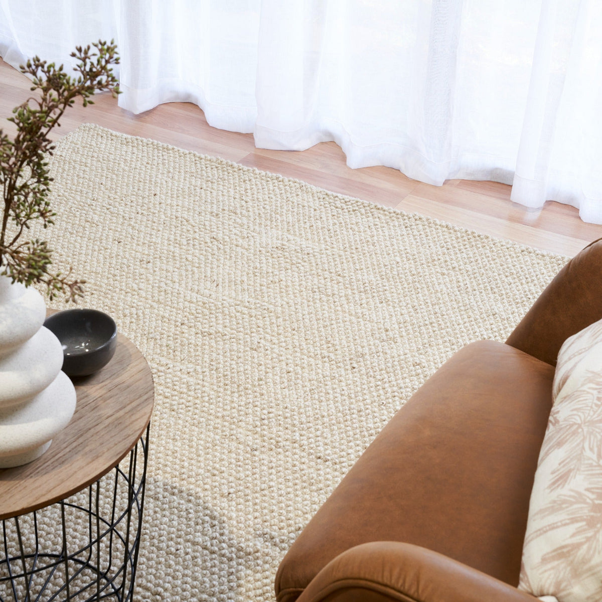 Cream woven area rug laid out on a floor