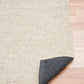 Cream rug corner with dark backing on underside