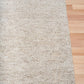 Light beige textured woven area rug with straight edge