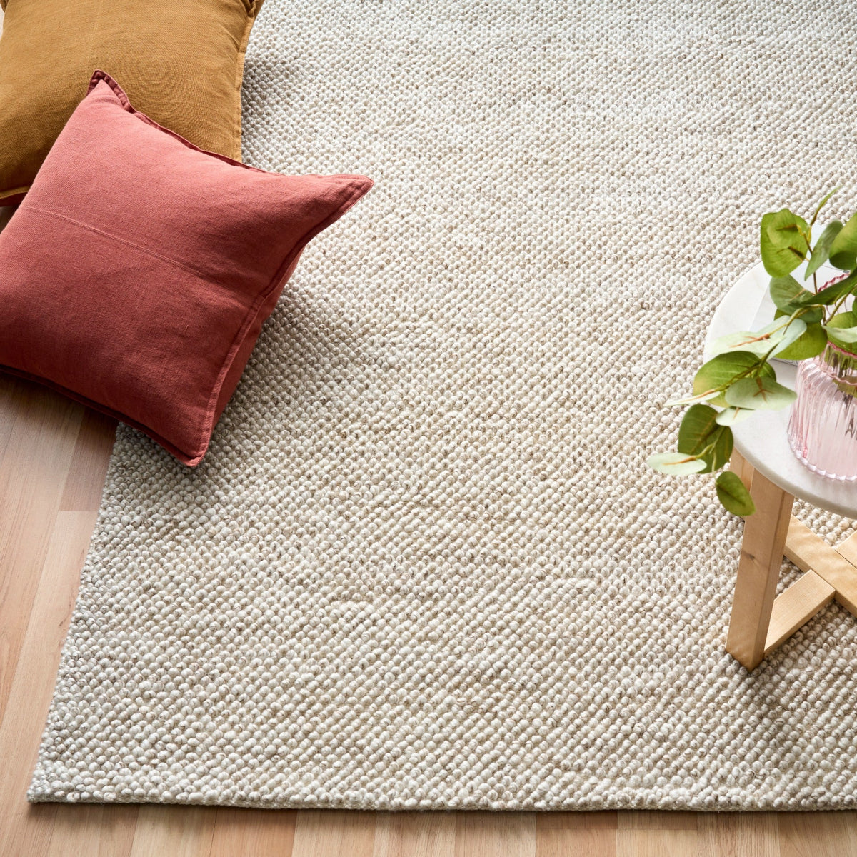 Light beige textured woven area rug corner view