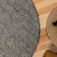 Grey textured round rug edge with speckled weave detail