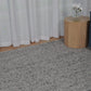 Grey speckled area rug with low-pile, textured surface