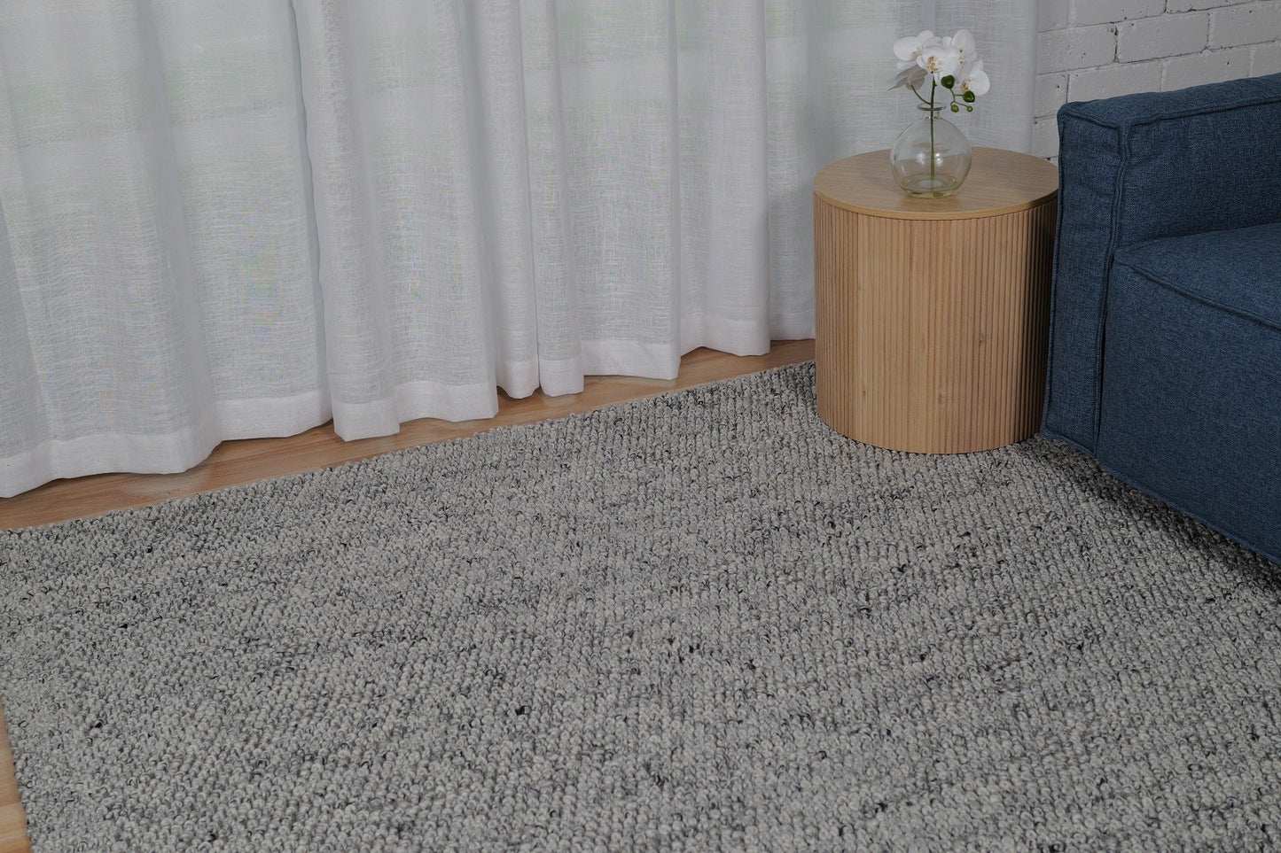 Grey speckled area rug with low-pile, textured surface