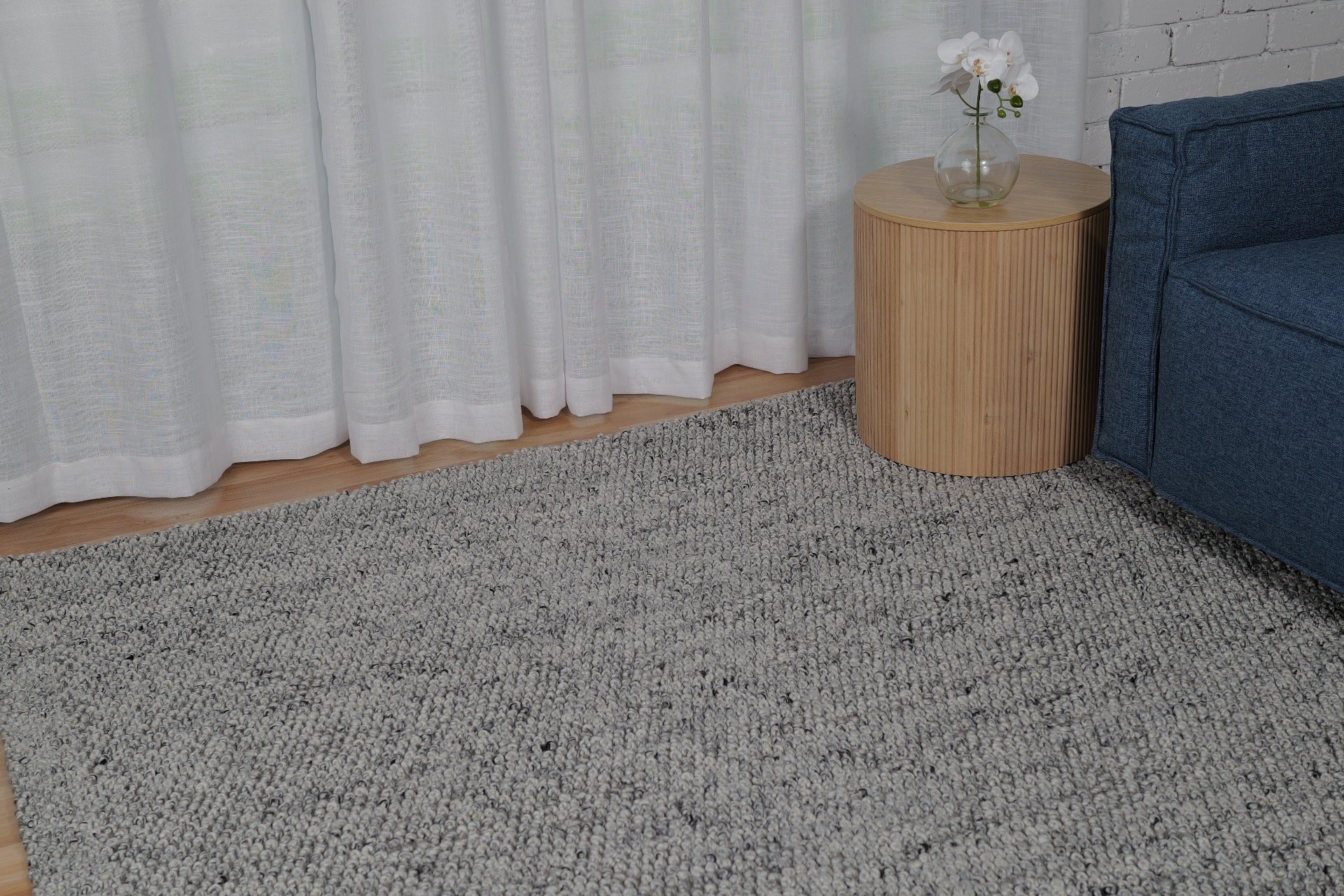 Grey speckled area rug with low-pile, textured surface