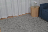Grey speckled area rug with low-pile, textured surface