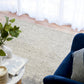 Grey textured area rug with boucle loop surface laid on light wood floor