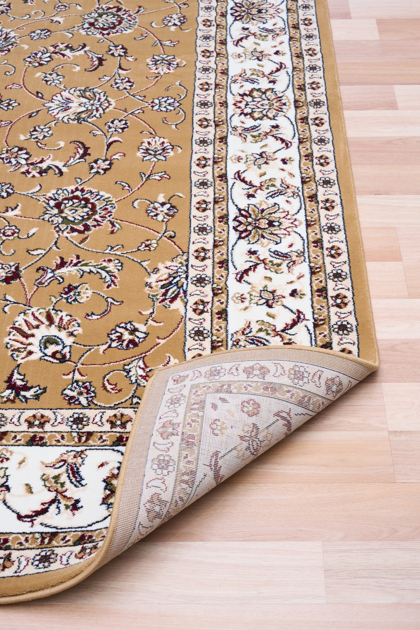 Berber-style area rug corner close-up, tan floral pattern with white ornamental border