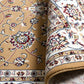 Berber-style rug fabric close-up with tan background, multicolor florals, and rolled edge