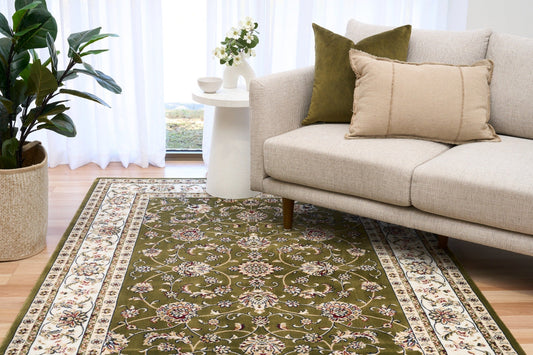 BALUCHI green floral area rug styled on floor with patterned border and center medallion