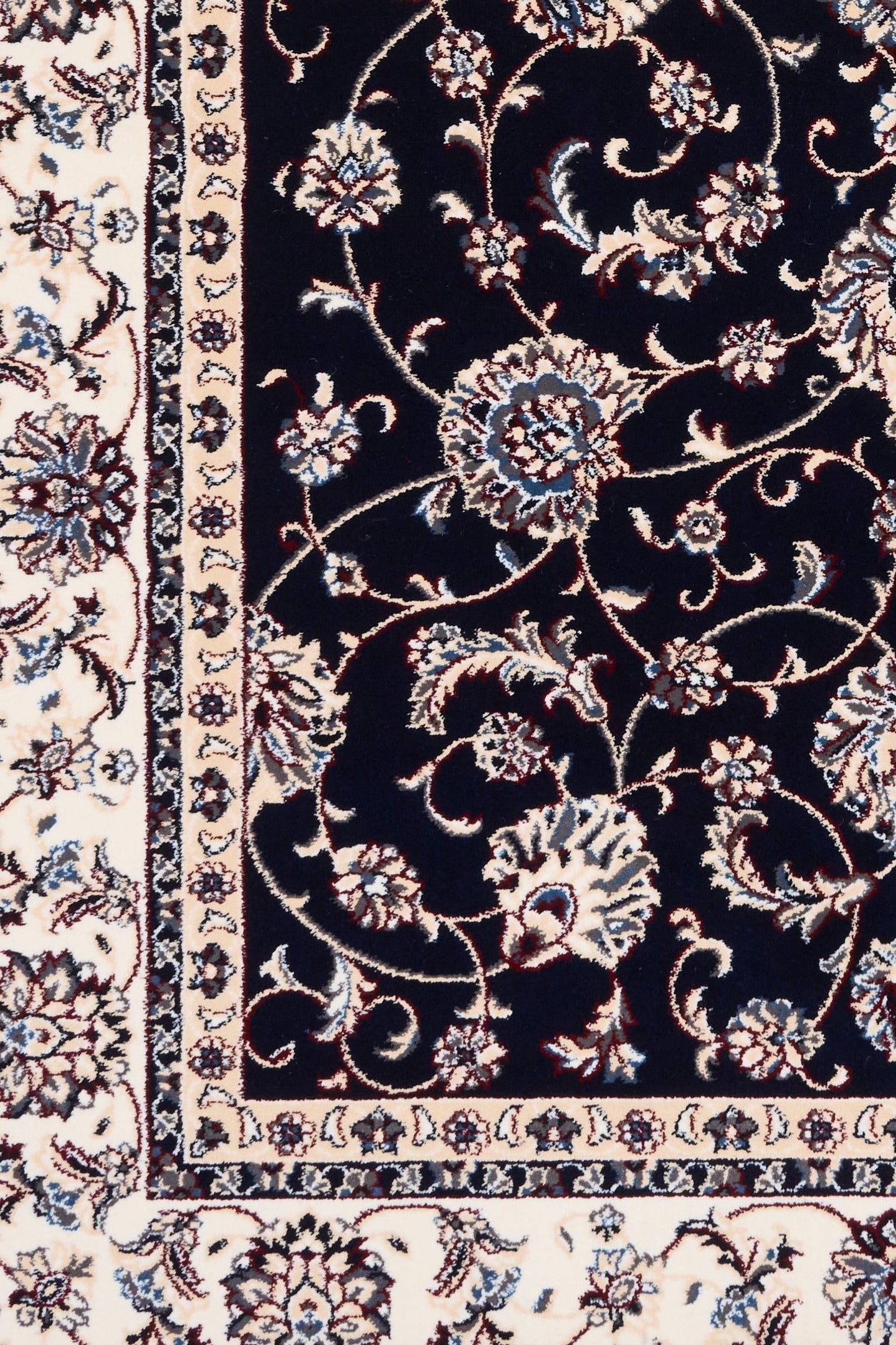 BALUCHI navy area rug close-up of floral scrollwork and cream edge border