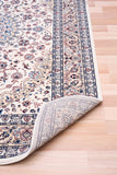 Ivory area rug corner with patterned border and folded edge view