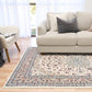 Ivory area rug laid out with ornate floral pattern and navy border stripe