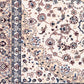 Ivory rug detail with navy and blue border stripes and floral motifs